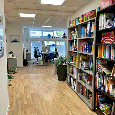 Eingangsbereich der Schülerhilfe Kenzingen Der Eingangsbereich der Schülerhilfe Kenzingen mit einem Bücherregel und einem Schreibtisch.