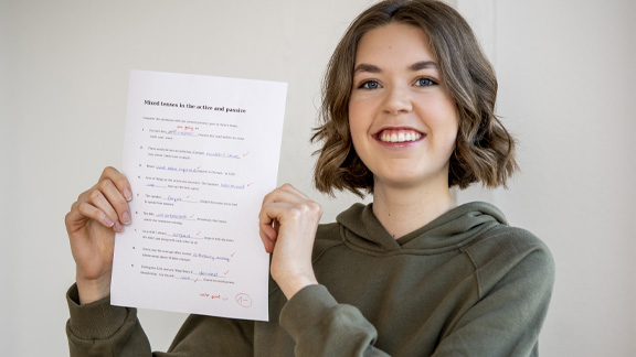 Prüfungen mit der Nachhilfe der Schülerhilfe bestehen Mädchen hält guten Schultest hoch
