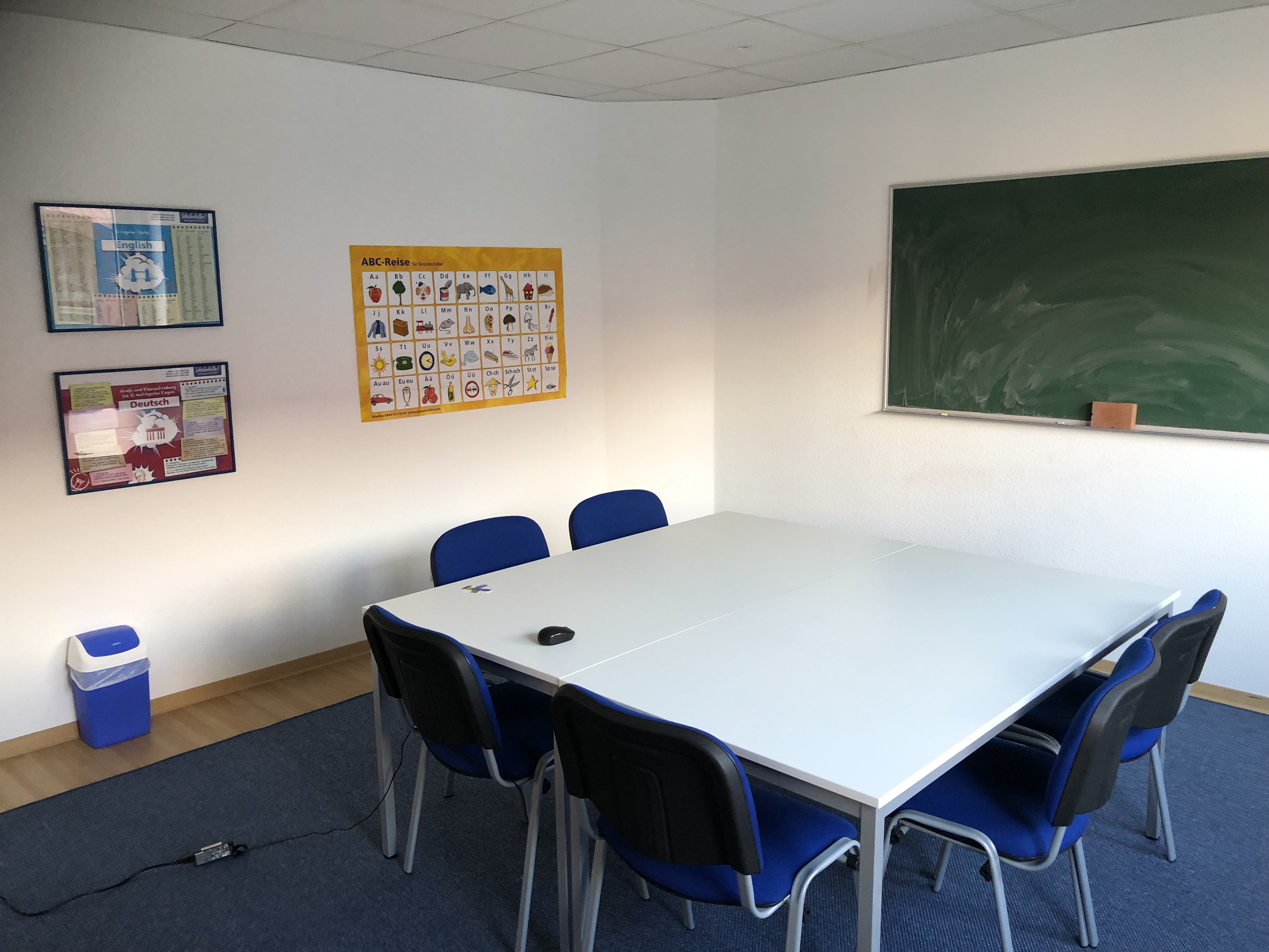 Innenansicht eines Unterrichtsraums in der Schülerhilfe Cuxhaven mit Tafel, Stühlen und einem Tisch.