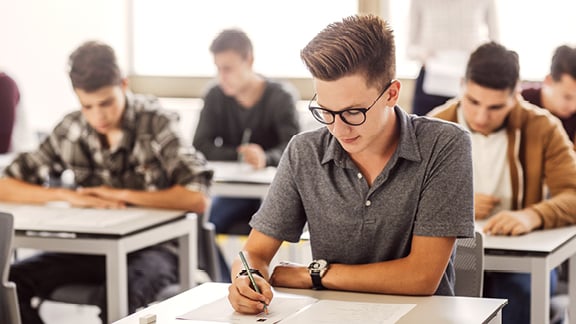 Abiturvorbereitung bei der Schülerhilfe Ein Schüler sitzt in einer Abiturprüfung.